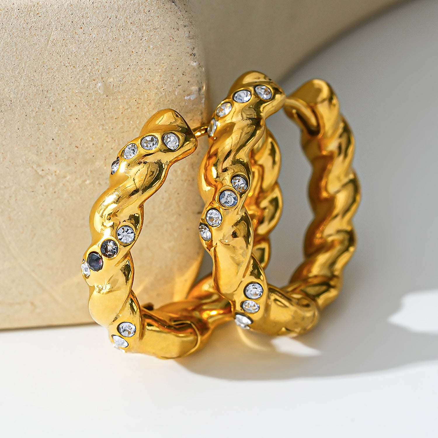 Style KAMENZ 50178: Twisted Textured Hoop Earrings with Zirconia Embellishments.