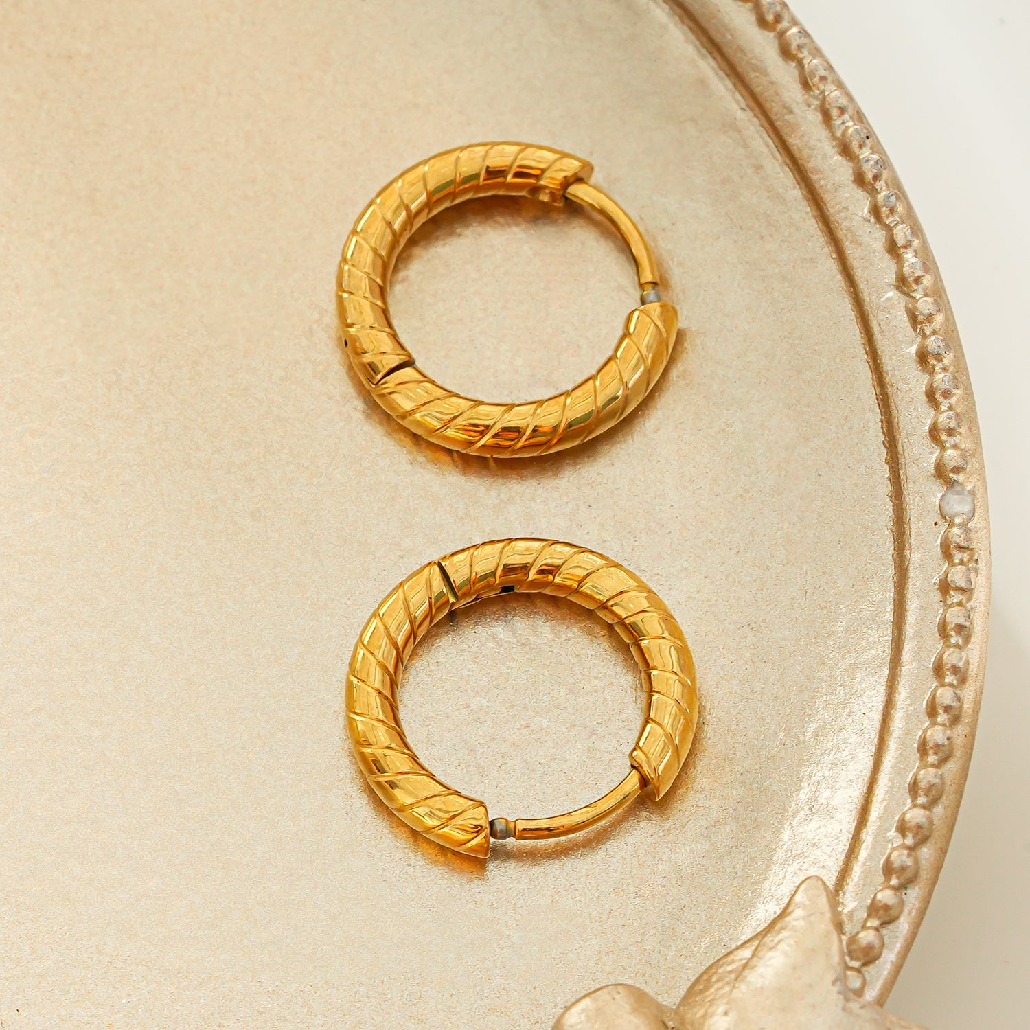 LUPITA: Swirl Design Textured Hoop Earrings in Gold