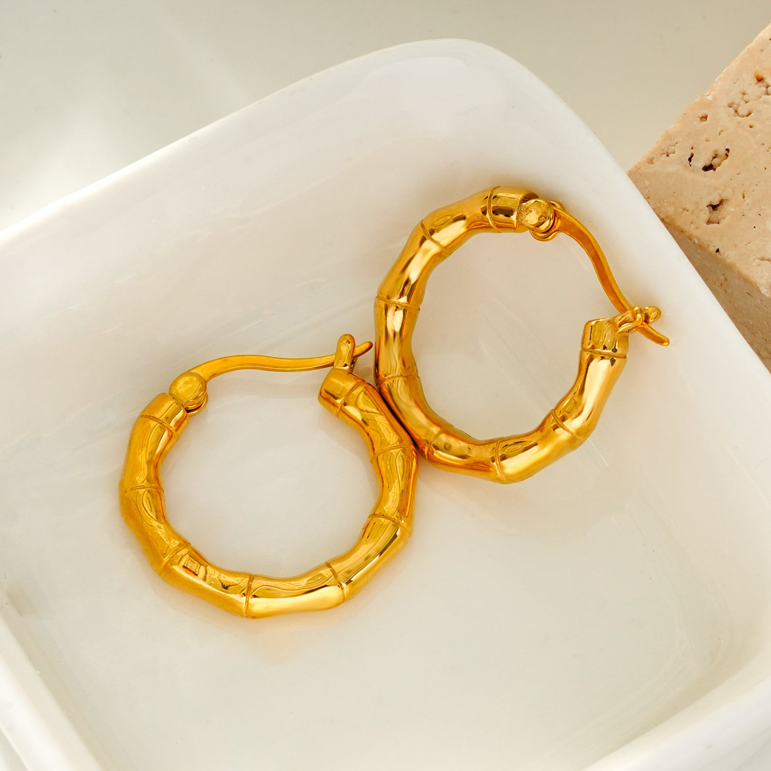 METIOS: Bamboo Textured Hoop Earrings in Gold